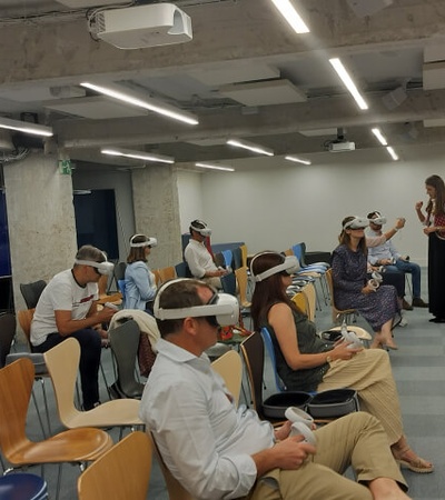 A group of people wearing VR headsets in a modern office setting.