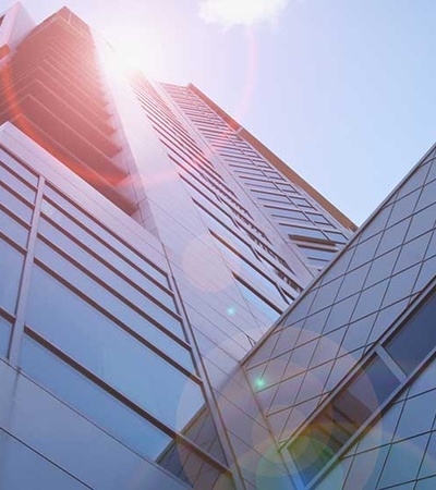 Low angle view of a modern skyscraper with sun flare.