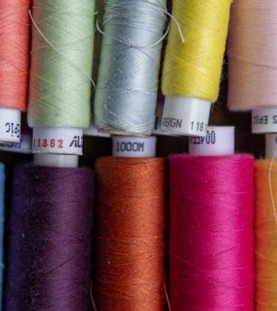 Close-up of a collection of colorful thread spools arranged tightly together.