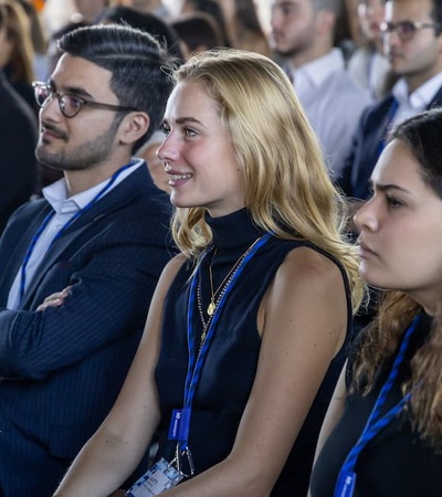 A group of young adults attentively listening at an event.