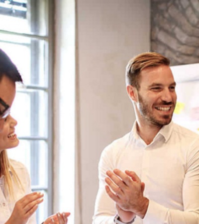 a group of 4 people business man style dressed talking and laughing 