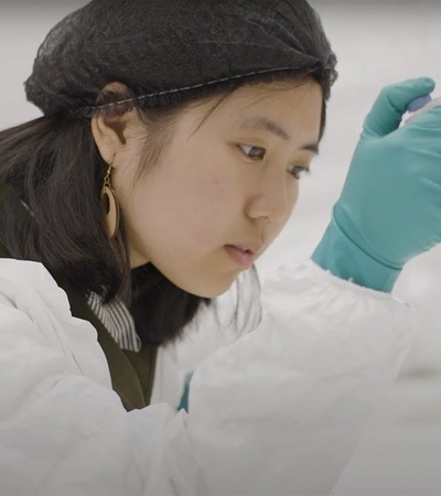 A focused scientist using a pipette in a laboratory.