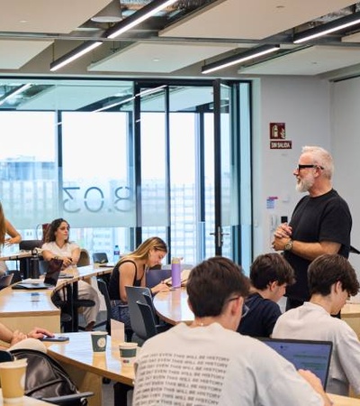 A teacher is instructing a group of students in a modern classroom.
