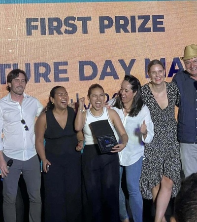 A group of people celebrating a first prize win at Venture Day Madrid, posing joyfully with a trophy.