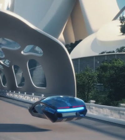 A futuristic vehicle driving on a sleek bridge with distinctive architectural features in a modern city environment.