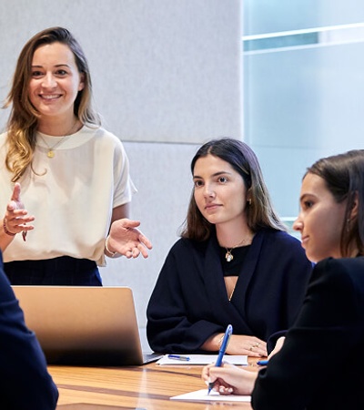 A business meeting where a woman is presenting to a small group.