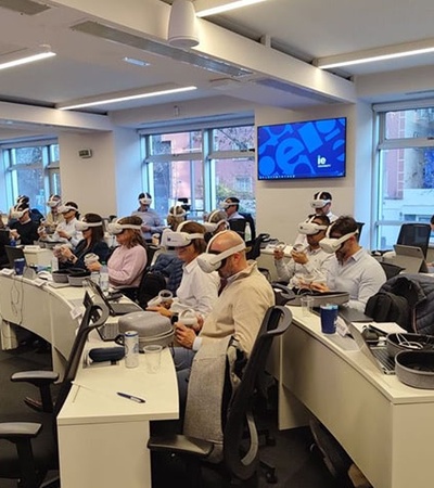 A group of people wearing VR headsets in a modern classroom setting.