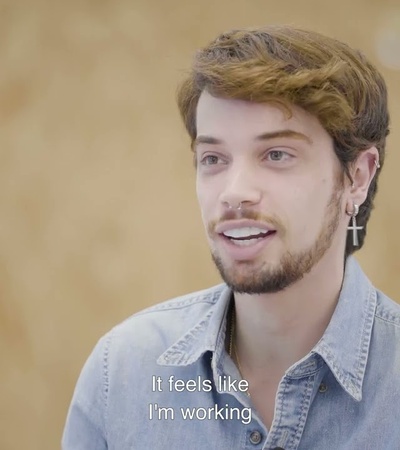 A young man speaking in an interview setting.