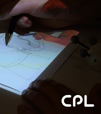 A person tracing an image on paper using a light box.