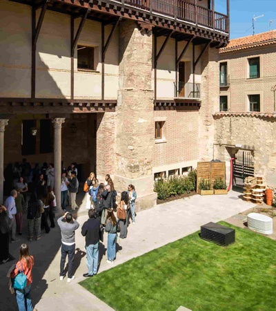 A group of people gathered in a courtyard surrounded by historic buildings.