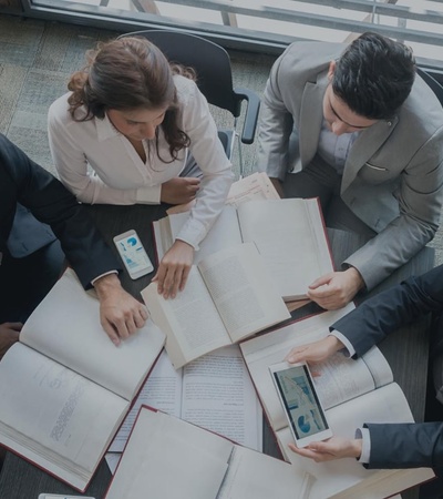 A group of professionals reviewing documents around a table.