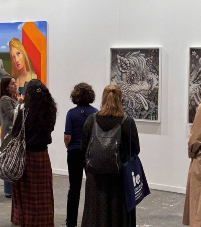 A group of people is observing artwork in a gallery setting.