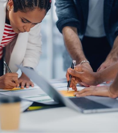 A group of professionals engaged in a discussion while reviewing documents on a table.