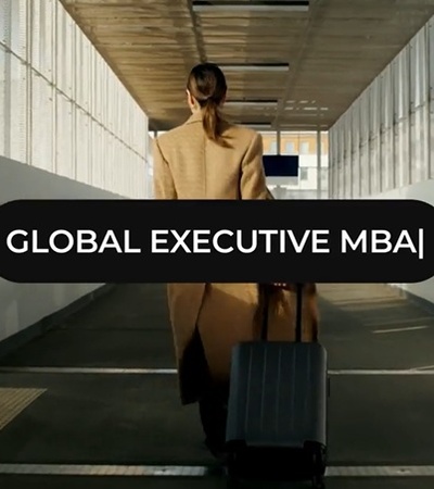 A professional individual walking with a suitcase in a modern corridor.