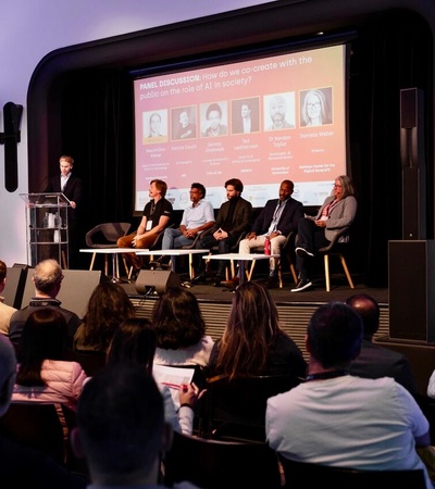 A panel discussion taking place in front of an audience.