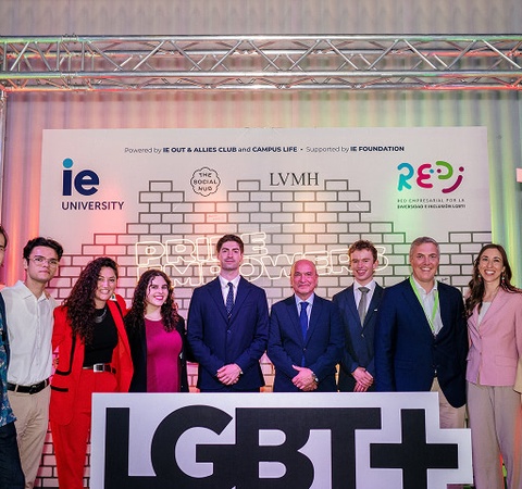 A group of individuals poses together at an event promoting LGBTQ+ inclusion.