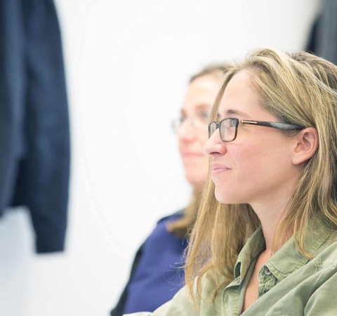 Blonde woman with glasses in a class