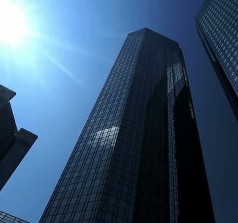 A view of tall skyscrapers against a clear blue sky.