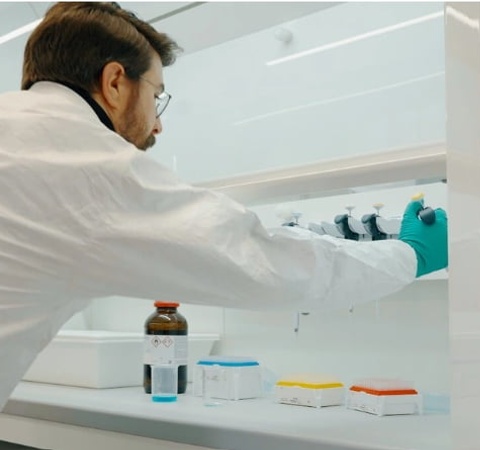 A laboratory technician is working with equipment in a clean lab environment.