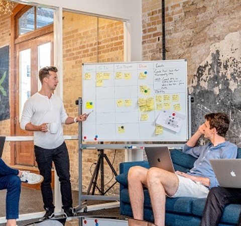 Meeting with a speaker pointing to a blackboard