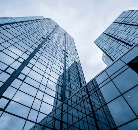 Low angle view of modern glass skyscrapers with reflections of clouds.