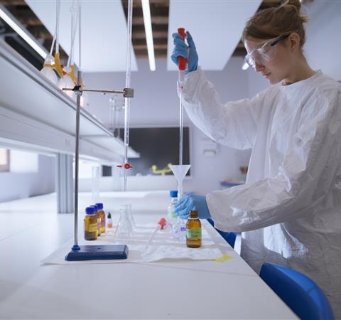 A scientist in a lab coat conducts an experiment in a modern laboratory.
