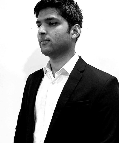 A black and white photo of a young man in a suit looking to the side.