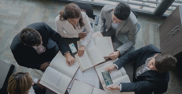A group of professionals reviewing documents around a table.