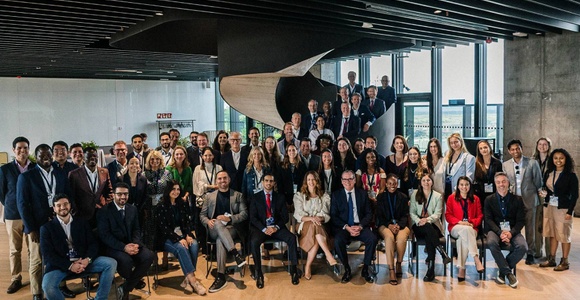 A large group of people posing for a photo in a modern office space.