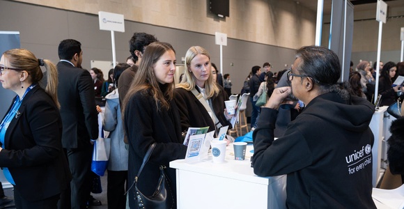 A group of people engaged in conversation at a professional event.