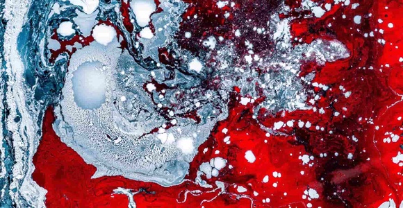 An abstract image featuring swirling red and blue colors with intricate textures and patterns.