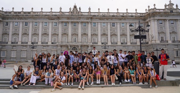 A large group of people gathered in front of a grand building.