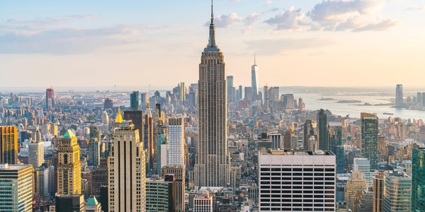 A panoramic view of a bustling city skyline featuring the Empire State Building.