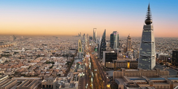 A panoramic view of Riyadh's skyline at sunset featuring modern skyscrapers.
