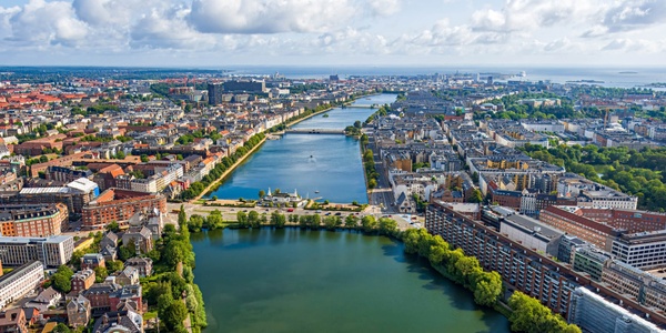 A panoramic view of a vibrant city landscape with rivers and greenery.