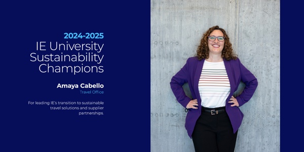 A woman in a purple blazer stands confidently next to a gray wall, representing a sustainability champion.