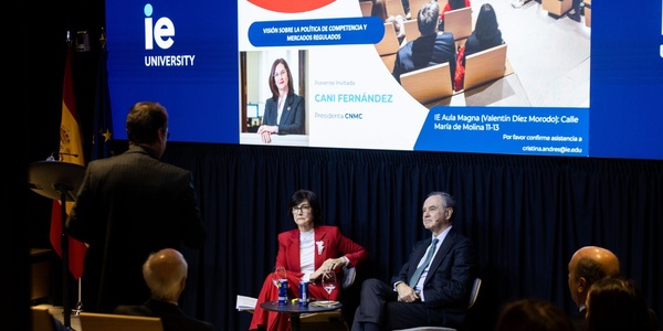 A conference setting with speakers discussing in front of an audience at IE University.