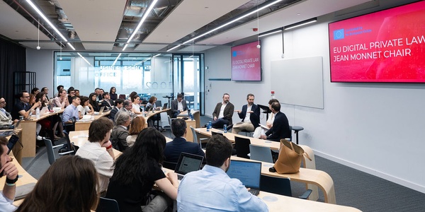 A conference room filled with attendees listening to a panel discussion on EU digital private law.