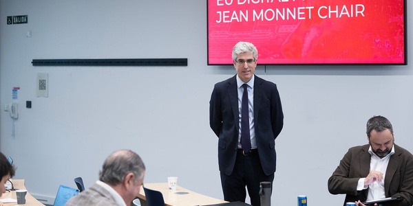 A man stands in front of a screen displaying information about EU Digital Private Law.