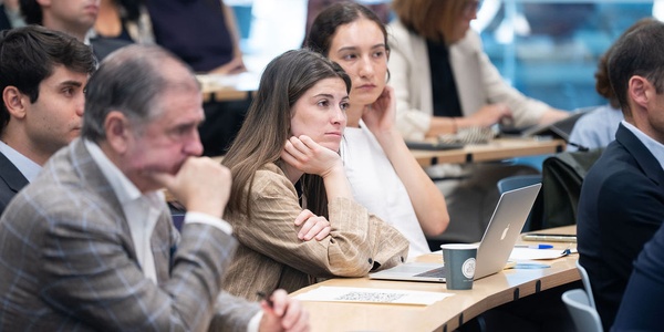 A group of people attentively listening during a conference or presentation.