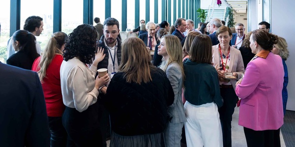 A diverse group of professionals engaging in conversation at a corporate event.