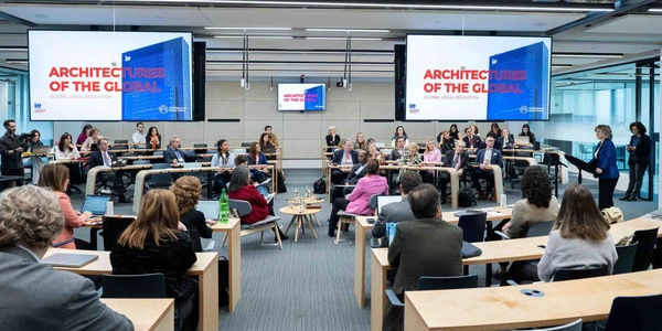 A conference taking place with multiple participants seated at tables in a modern venue.