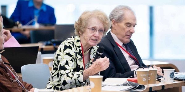 A group of people engaged in discussion at a conference setting.