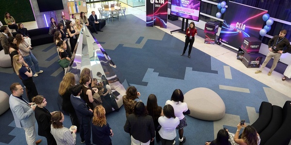 A group of people gathered in a modern indoor space for a presentation.