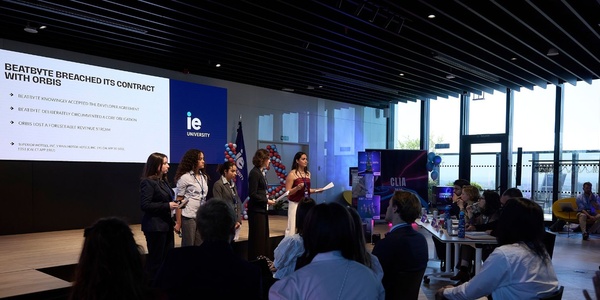 A group of students presenting at a university event with a presentation displayed on the screen.