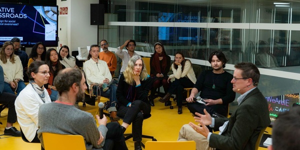 A group of people are engaged in a discussion inside a modern office environment.