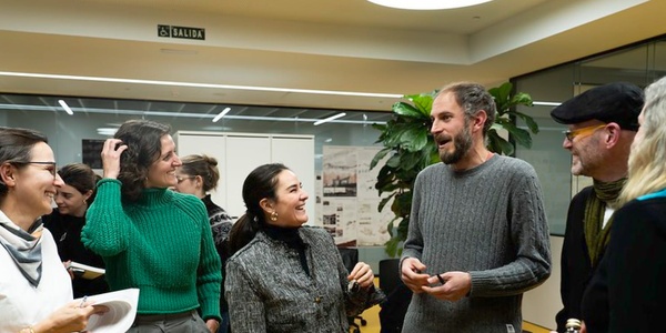 Group of people engaging in conversation indoors at an event.