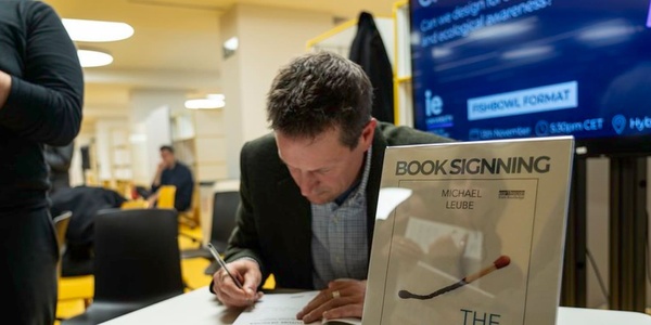 A man signing a book at a book signing event