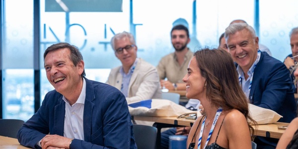 A group of people smiling and engaging in a lively discussion during a meeting.