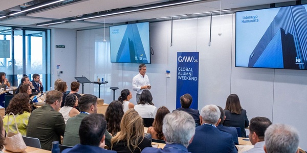 A speaker presents to an engaged audience during a Global Alumni Weekend event.